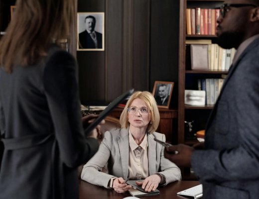 2 Employees Standing in Front of Female Employment Attorney